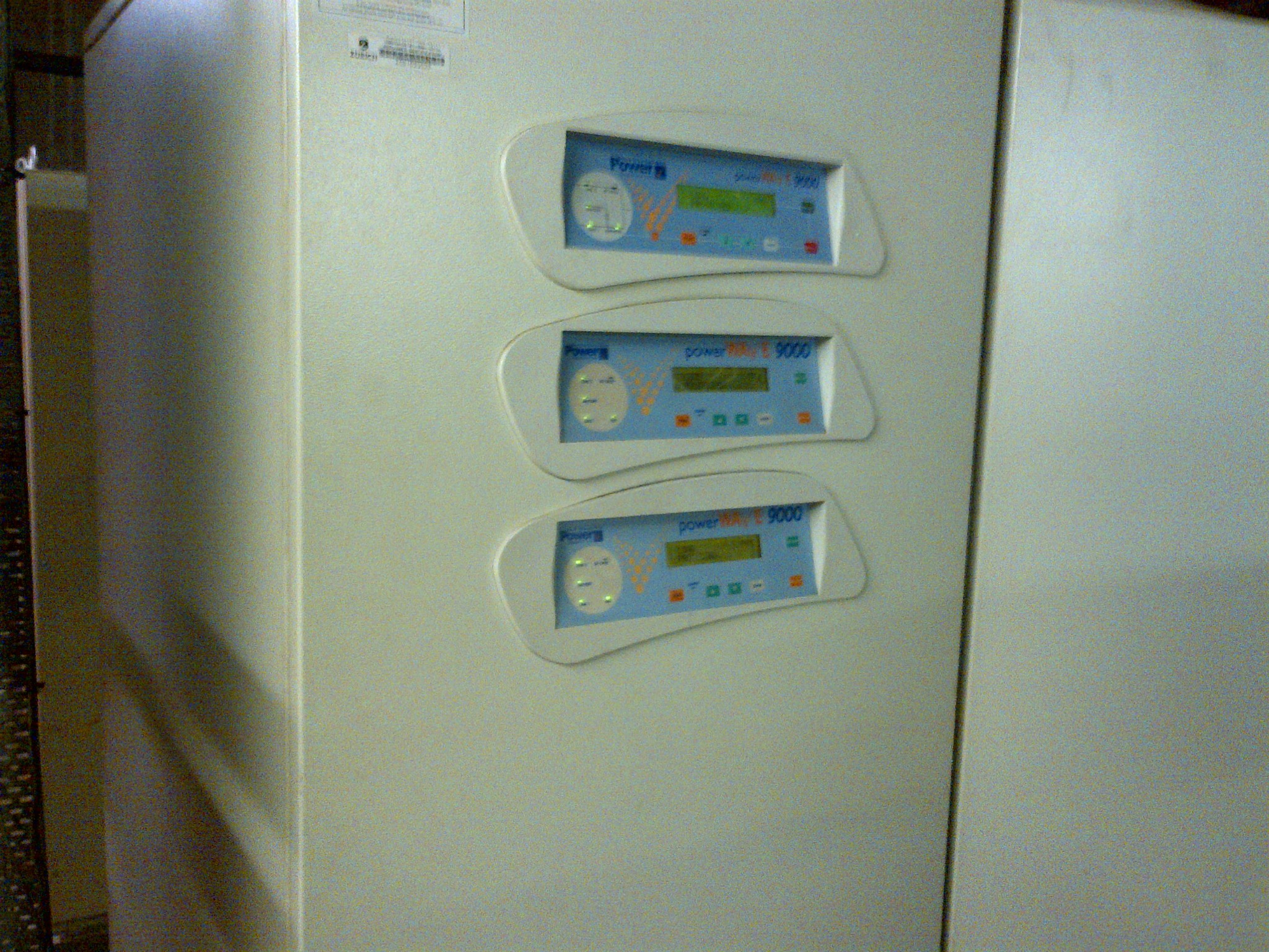 Front-panel displays on a modular UPS photographed during field-service work.